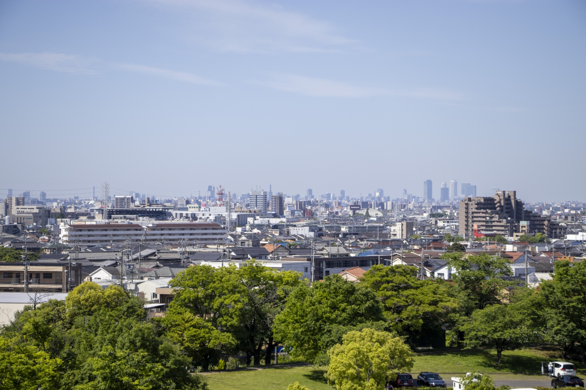春日井市の街並みと遠くに広がる名古屋市の高層ビル群(愛知県内の住宅エリアイメージ)